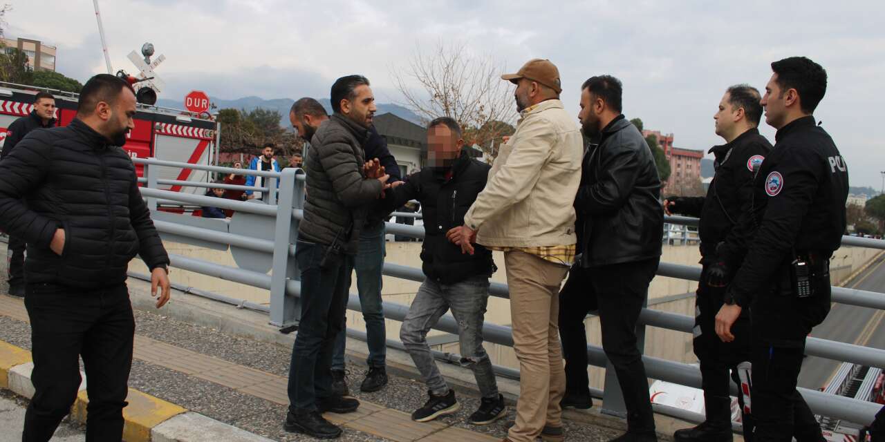 Çocukları için alt geçidin korkuluklarına çıktı